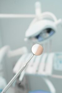 A dental professional discusses a treatment plan with an adult patient in a dental exam room.